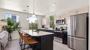 A modern kitchen with a central island, stainless steel appliances, and a view of the outdoors. - Luxury Apartment in Salt Lake City (Salt Lake City)