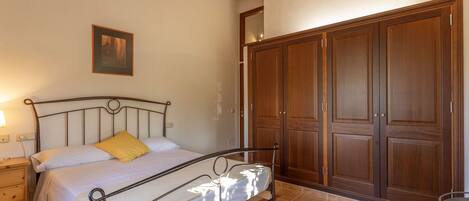 Una camera da letto con un letto, un'armadietto in legno e un comodino.