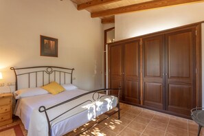 Une chambre à coucher avec un lit, une armoire en bois et une table de chevet.