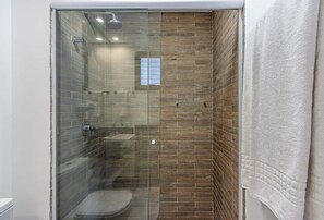 Eenvoudige studio | Badkamer | Een douche, een haardroger, handdoeken, zeep