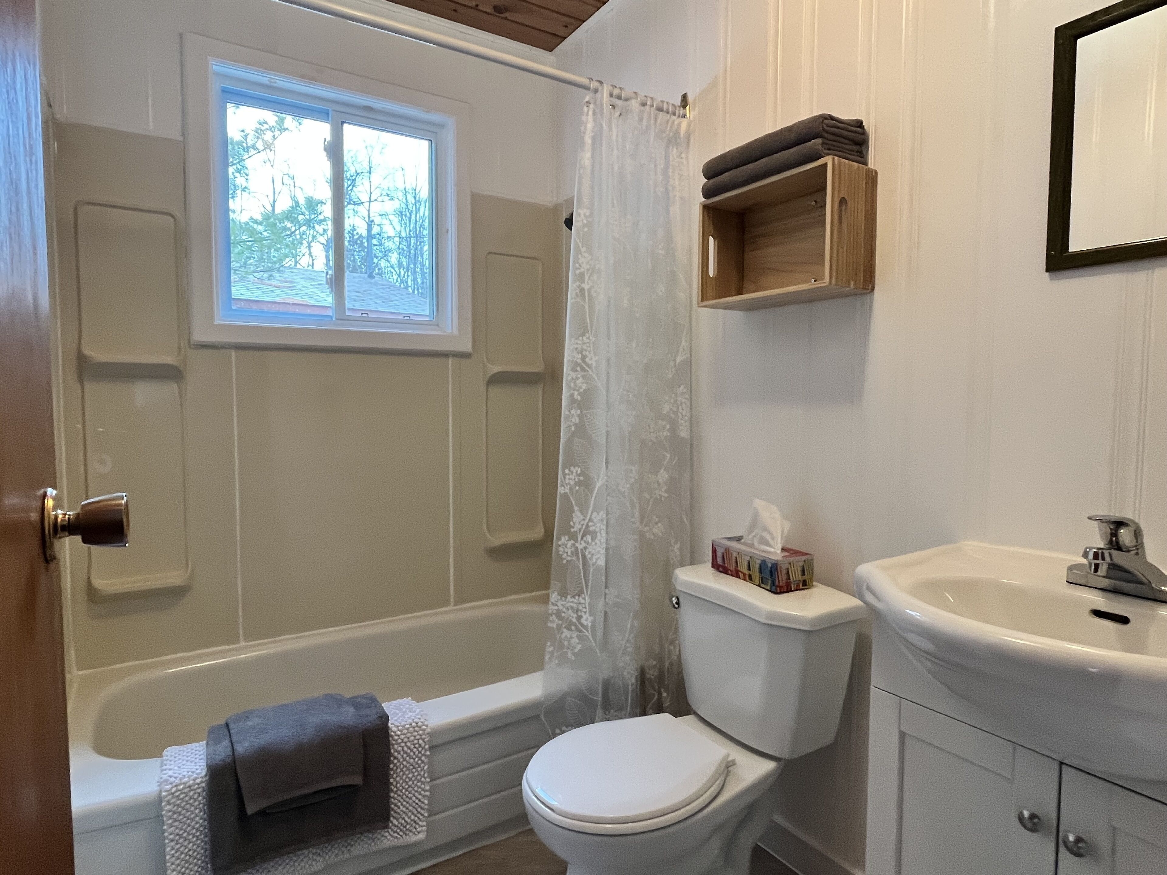 Een badkamer met een bad, toilet en wastafel.