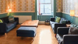 A living room with two sofas, a wooden coffee table, and a radiator.