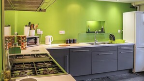A modern kitchen with a gas stove, a microwave, a sink, and a refrigerator.
