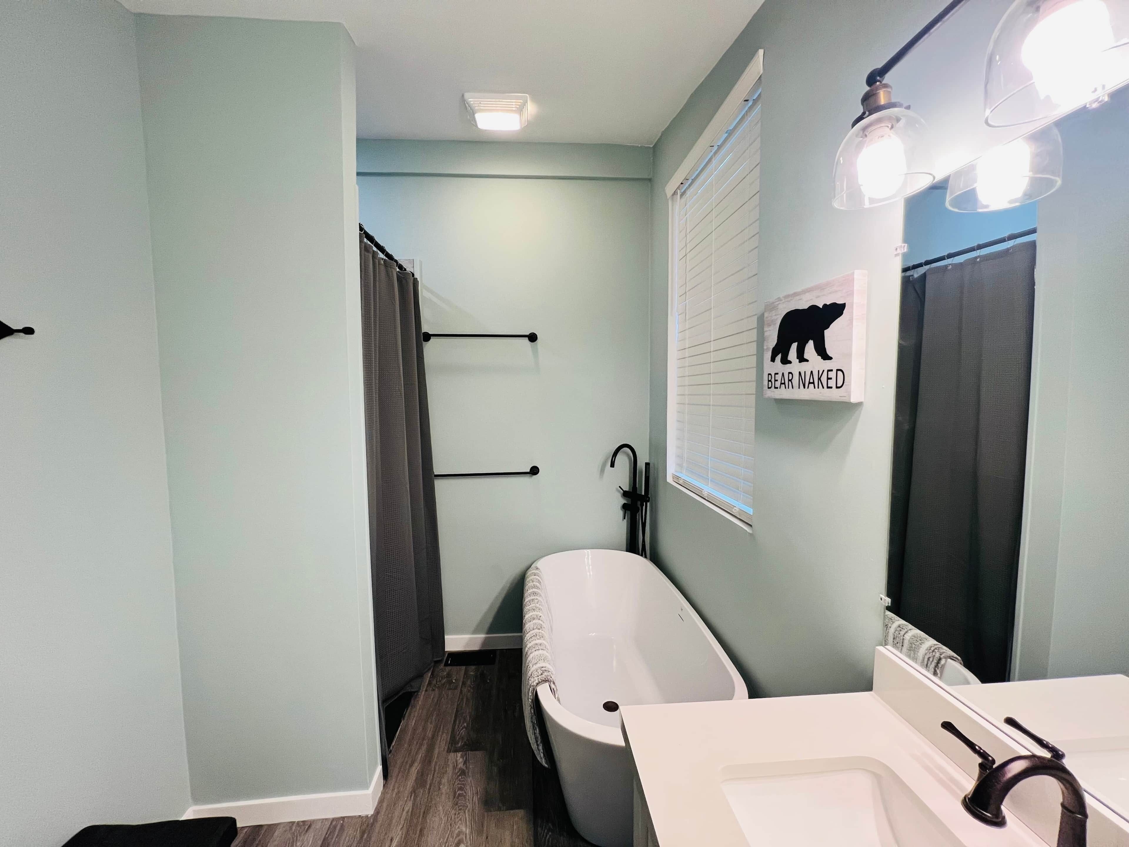A bathroom with a bathtub, a sink, and a towel rack.