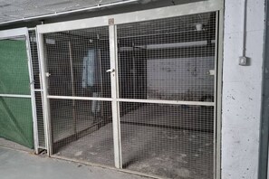 Una reja de metal con el número 12, adosada a un edificio de suelo de hormigón.