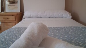Een bed met een wit kussen en een deken met een blauw sterrenpatroon.