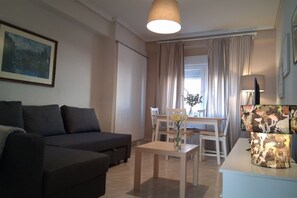 Una sala de estar con un sofá, una mesa con un florero y una lámpara.