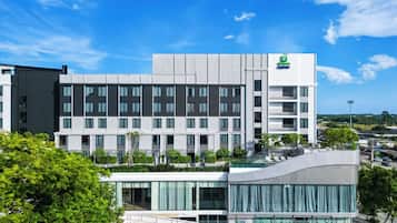 A modern hotel building with multiple floors, large windows, and a visible sign for Holiday Inn Express.
