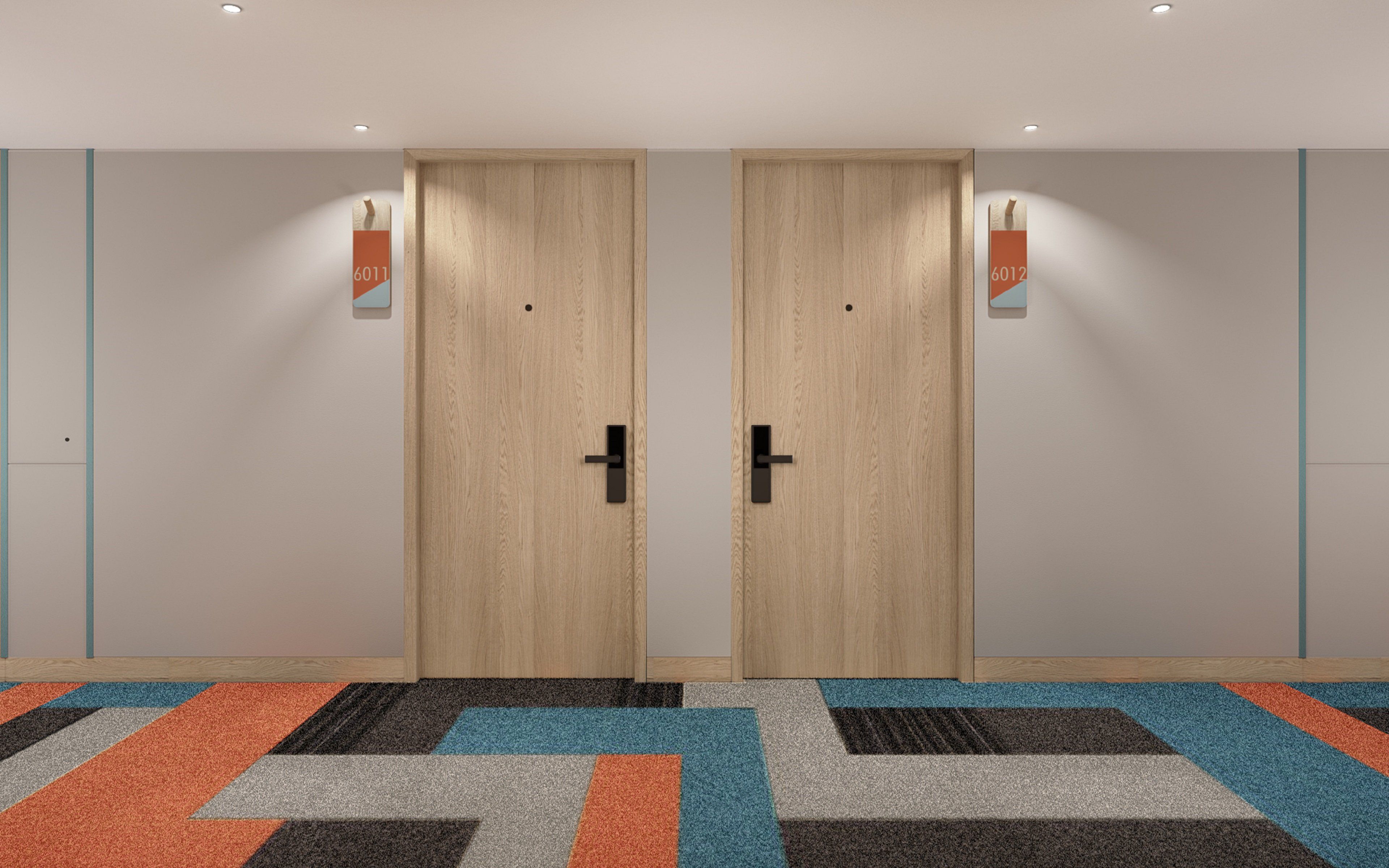 Un couloir avec deux portes en bois, chacune portant un numéro au-dessus.