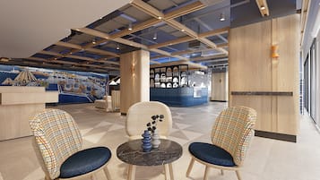 A modern lobby with a checkered chair set, a marble table, and a mural on the wall.