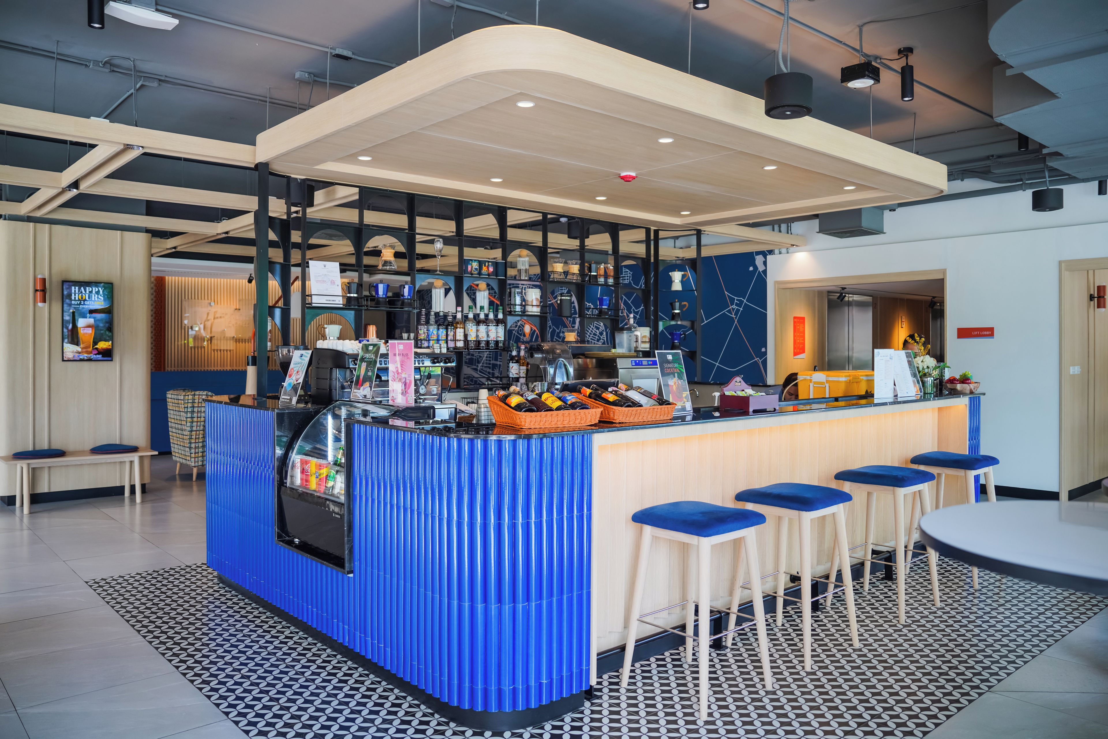 Un espace bar moderne avec des tabourets, un comptoir et diverses bouteilles.