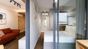 Una habitación de hotel moderna con cama, sofá y escritorio.