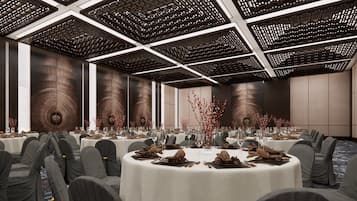 A conference room with round tables, grey chairs, and a modern ceiling design.