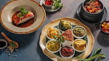 Variedad de platos sobre una mesa, incluyendo mariscos, curry y arroz.