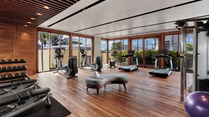 A spacious gym with various exercise equipment, large windows, and a wooden floor. - Holiday Inn Resort Bali Canggu by IHG (Canggu)