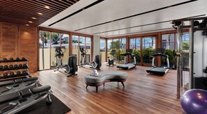 A spacious gym with various exercise equipment, large windows, and a wooden floor. - Holiday Inn Resort Bali Canggu by IHG (Canggu)