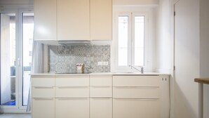 Una cocina moderna con armarios blancos y un salpicadero con estampado.