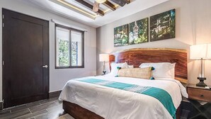 A modern bedroom with a large bed, a wooden headboard, and three paintings on the wall. - Bright Full Furnished 2 Bedrooms Waiting For You (Tulum)