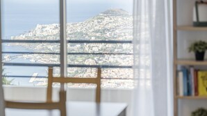 A view from a window overlooking a cityscape with buildings and a hill. - Casa da Ângela - By Wehost (Funchal)
