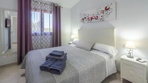 A bedroom with a bed, a nightstand, a lamp, and a wall art piece. - Finca Monika Natalia (Mayorca)