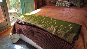 A cozy bedroom with a bed, a window with sheer curtains, and a view of greenery outside. - The Rustic Woodzie at Elk Creek Escape (Hillsgrove)