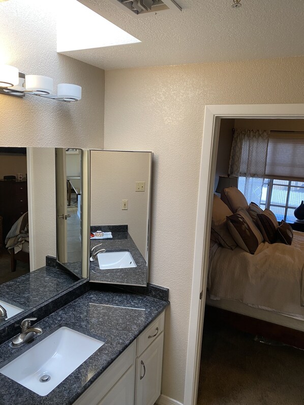A bathroom with a sink, mirror, and vanity. - Havasu Cozy Condo (Lake Havasu City)