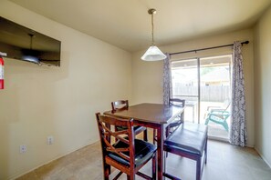 A dining area with a table and chairs, a ceiling light, and a view through a sliding glass door. - Fenced Yard, Workspace, Garage: Ft Worth Home Base (Fort Worth)
