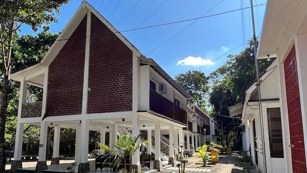 A two-story building with a covered patio area and a paved walkway.