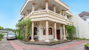 A two-story building with a balcony, columns, and a paved entrance area. - Hotel O Mw 46 Guesthouse (Yogyakarta)