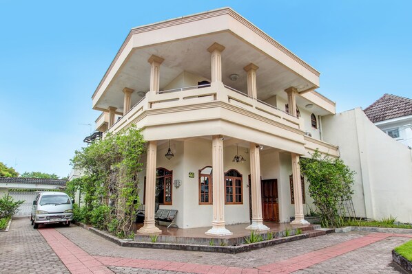 A two-story building with a balcony, columns, and a paved entrance area. - Hotel O Mw 46 Guesthouse (Yogyakarta)