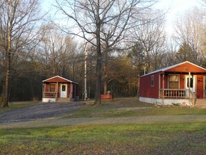 Two cabins with wooden exteriors, each featuring a porch and a door.