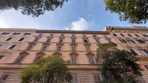 A multi-story building with a classical architectural style, featuring evenly spaced windows and a central entrance. - Roman Holiday Suites (Rome)