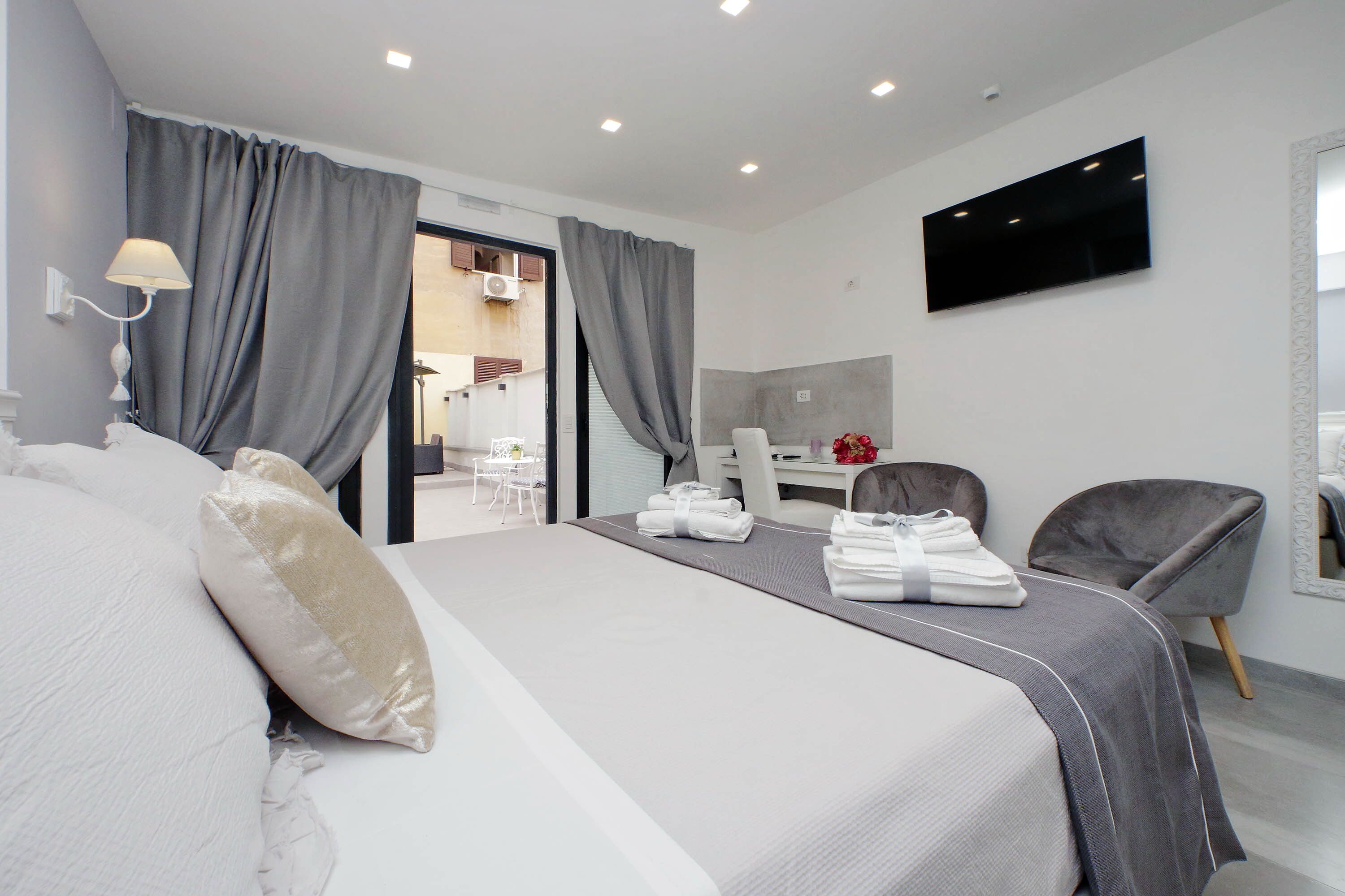 Une chambre d’hôtel moderne, dotée d’un grand lit, d’un bureau et d’une télévision.