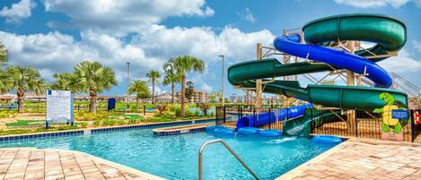 A water park with multiple slides, a swimming pool, and palm trees.