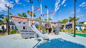 Un terrain de jeux sur le thème des pirates, comprenant un toboggan et des structures d’escalade.
