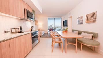 Una cocina moderna con comedor, sofá y televisor.