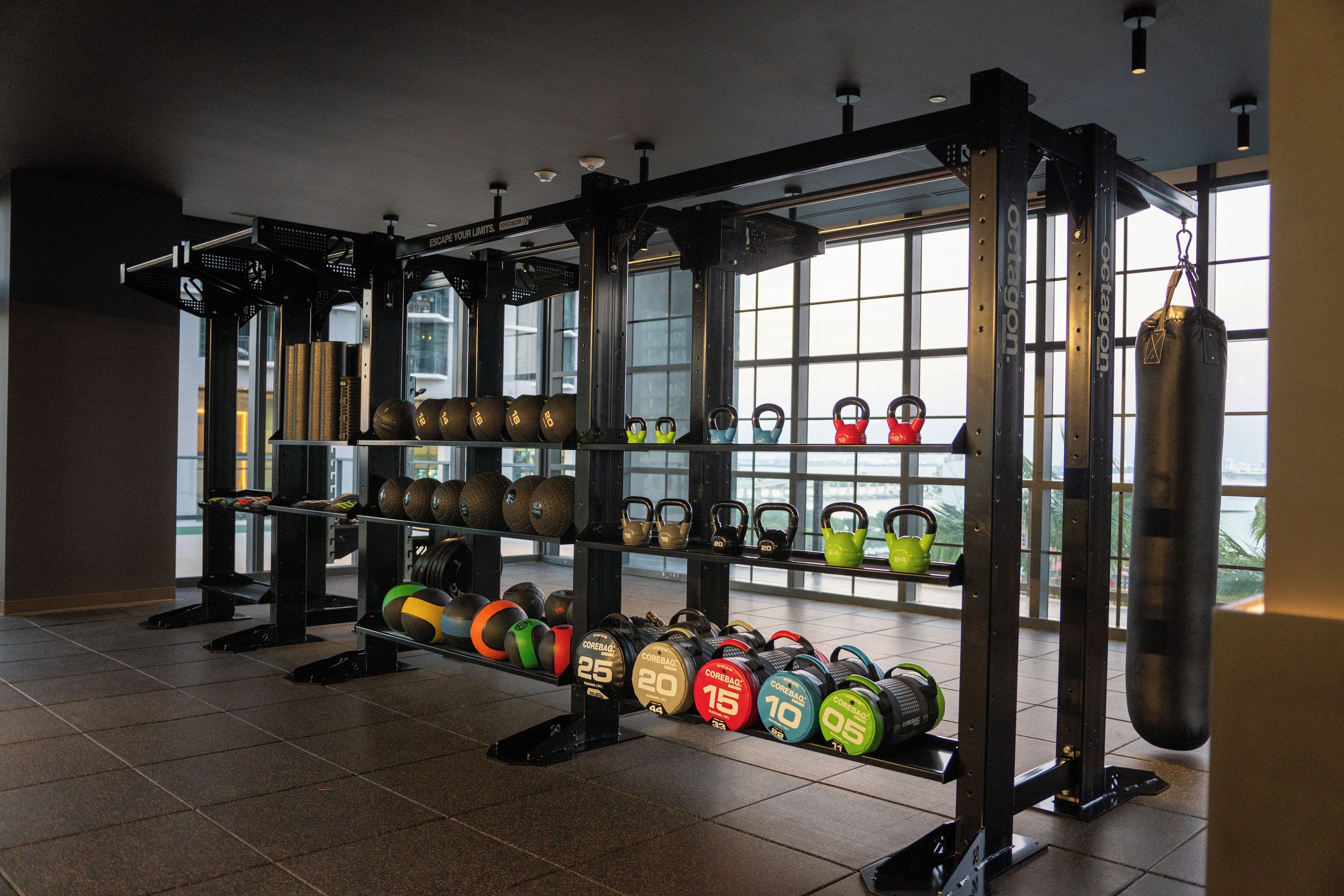 A gym with weightlifting equipment, including kettlebells and a punching bag.