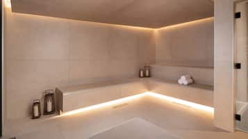 Une salle de bain moderne avec une grande baignoire, un éclairage encastré et un banc.