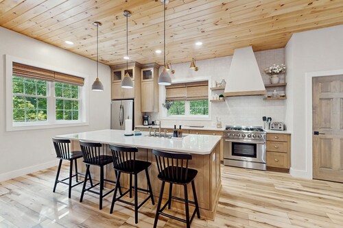 Stunning dog-friendly cottage with riverfront patio, hot tub, fire pit, & views