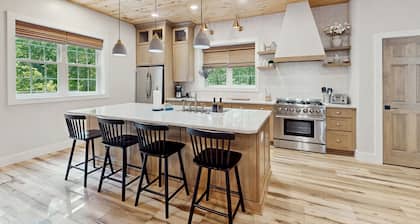 Stunning dog-friendly cottage with riverfront patio, hot tub, fire pit, & views