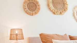 A bedroom with a bed, a bedside lamp, and two wall-mounted decorative items. - Luxury Village Home Close to Beaches and Wineries! (Arroyo Grande)