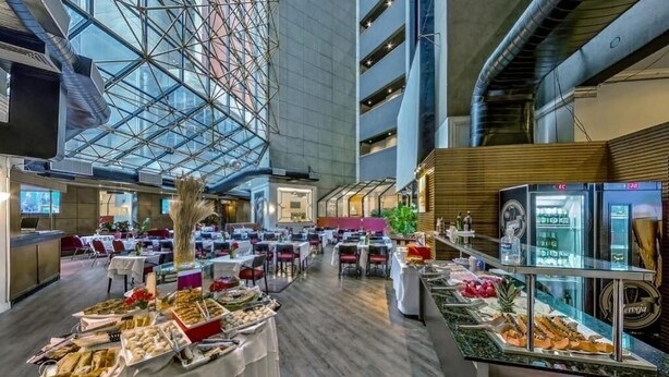 A spacious indoor dining area with multiple tables and a buffet setup. - Flat Massis 133 - Bela Vista (São Paulo)
