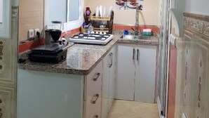 Una cucina piccola con un fornello a gas, un lavello e una finestra.