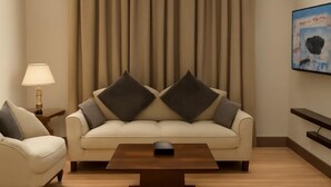 A modern living room with a sofa, a coffee table, and a lamp.