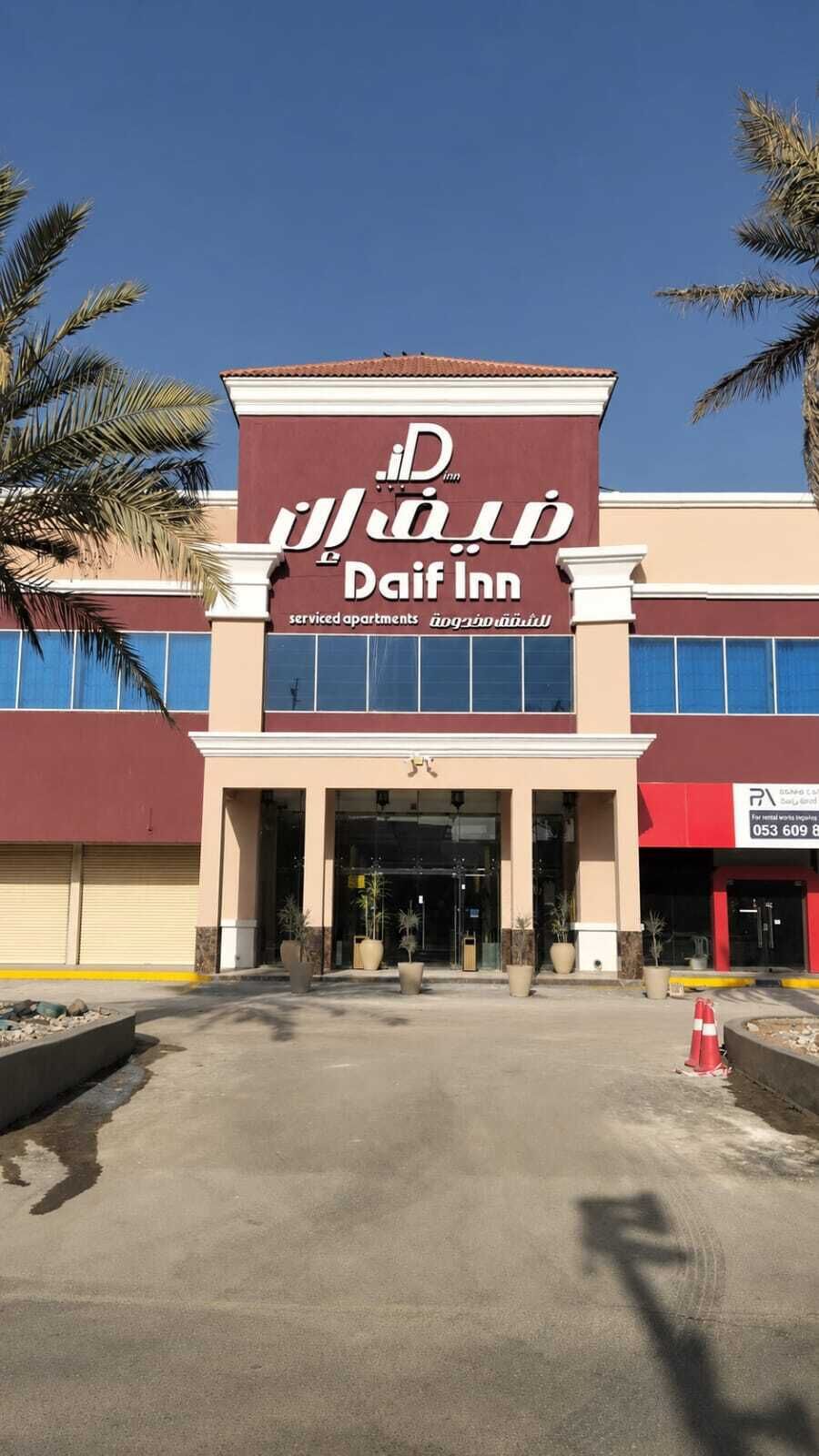 Un edificio con un letrero que dice 'Daif Inn' y una entrada visible.