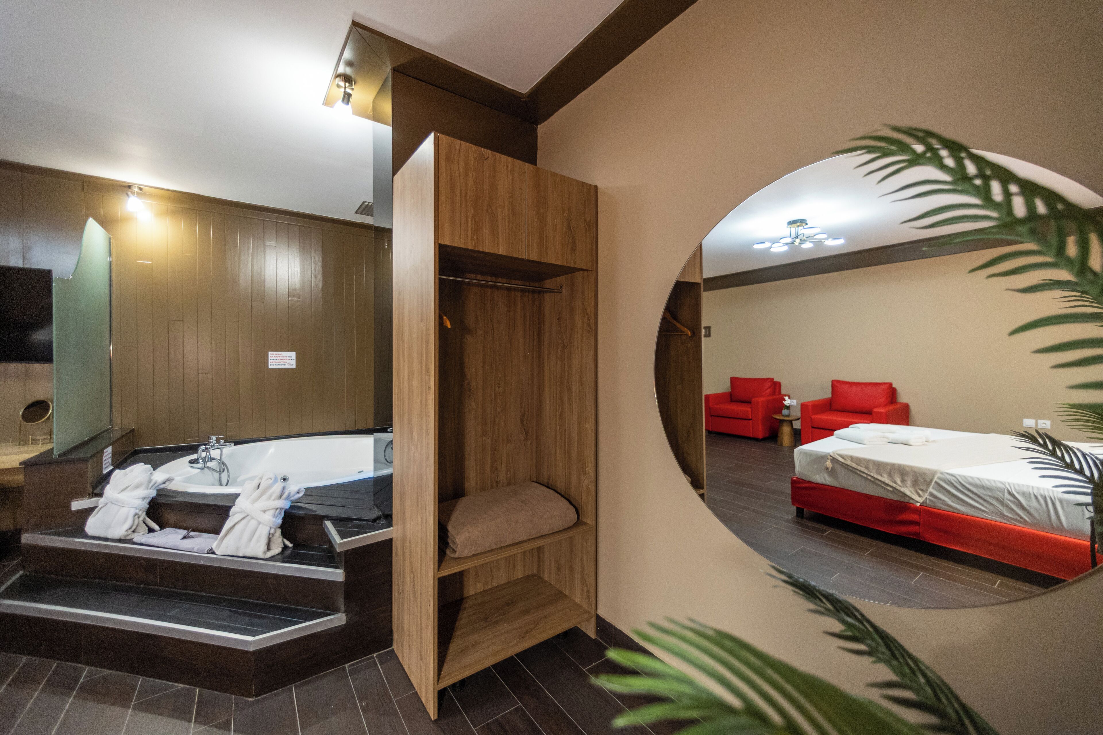 A modern bathroom with a bathtub, a wooden vanity, and a mirror.
