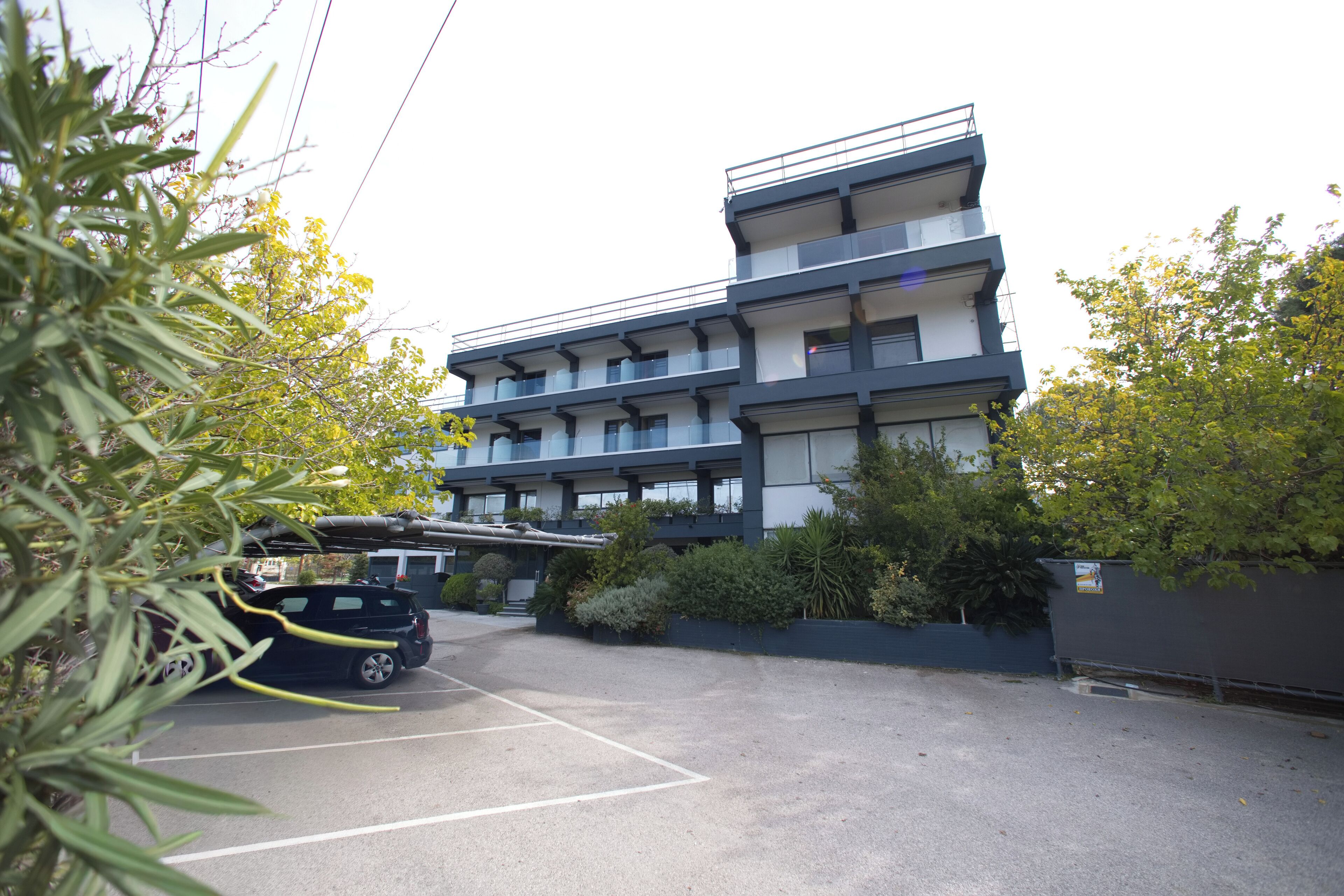 A multi-story building with a parking lot in front.