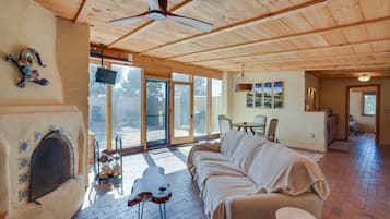 Una sala de estar acogedora con chimenea, un sofá y un comedor con mesa y sillas.