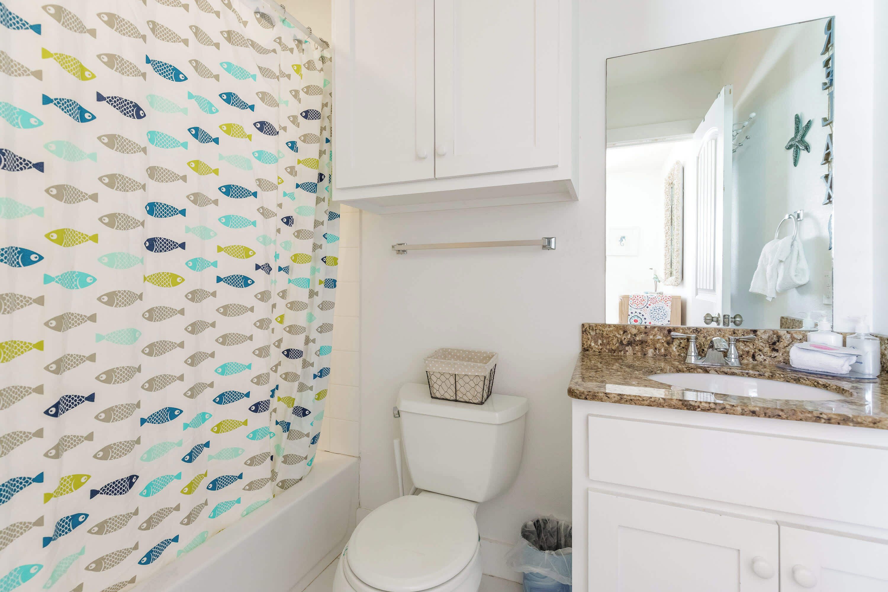 A bathroom with a toilet, a sink, and a mirror.