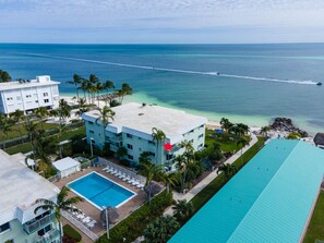 Ein Hotel mit Pool, Meerblick und einem großen Gebäude mit einem roten Stern auf dem Dach.